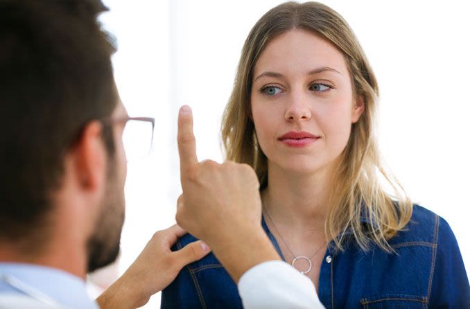 Woman's vision being tested by eye doctor