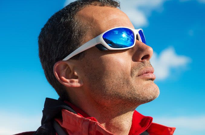 Man staring into sun wearing perfomance sunglasses.